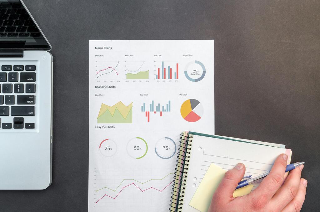 Mesa de trabajo con laptop, gráficos y reportes de datos para análisis institucional y empresarial